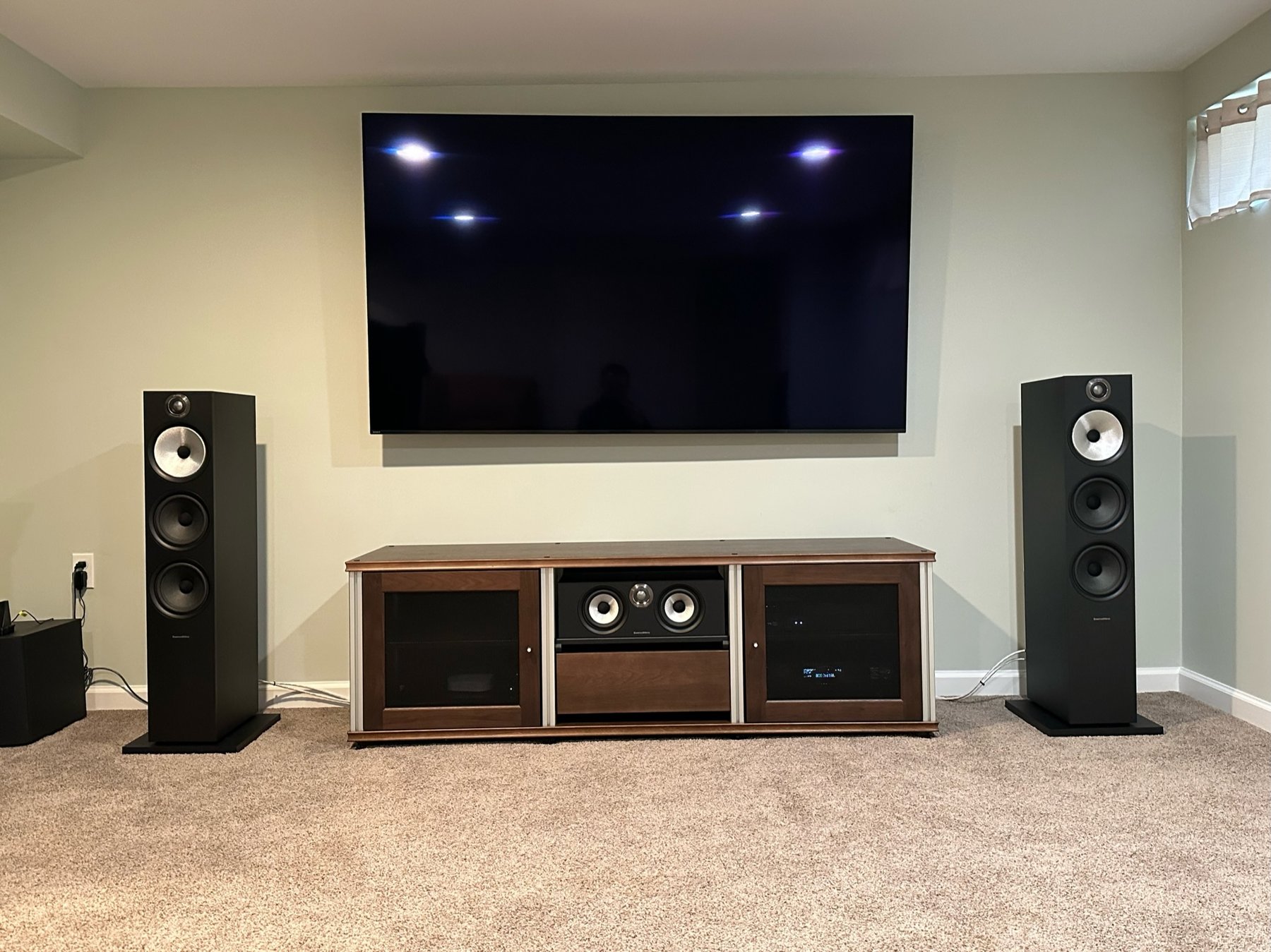 Mounted TV with Bowers and Wilkins floorstanding towers and center channel speaker